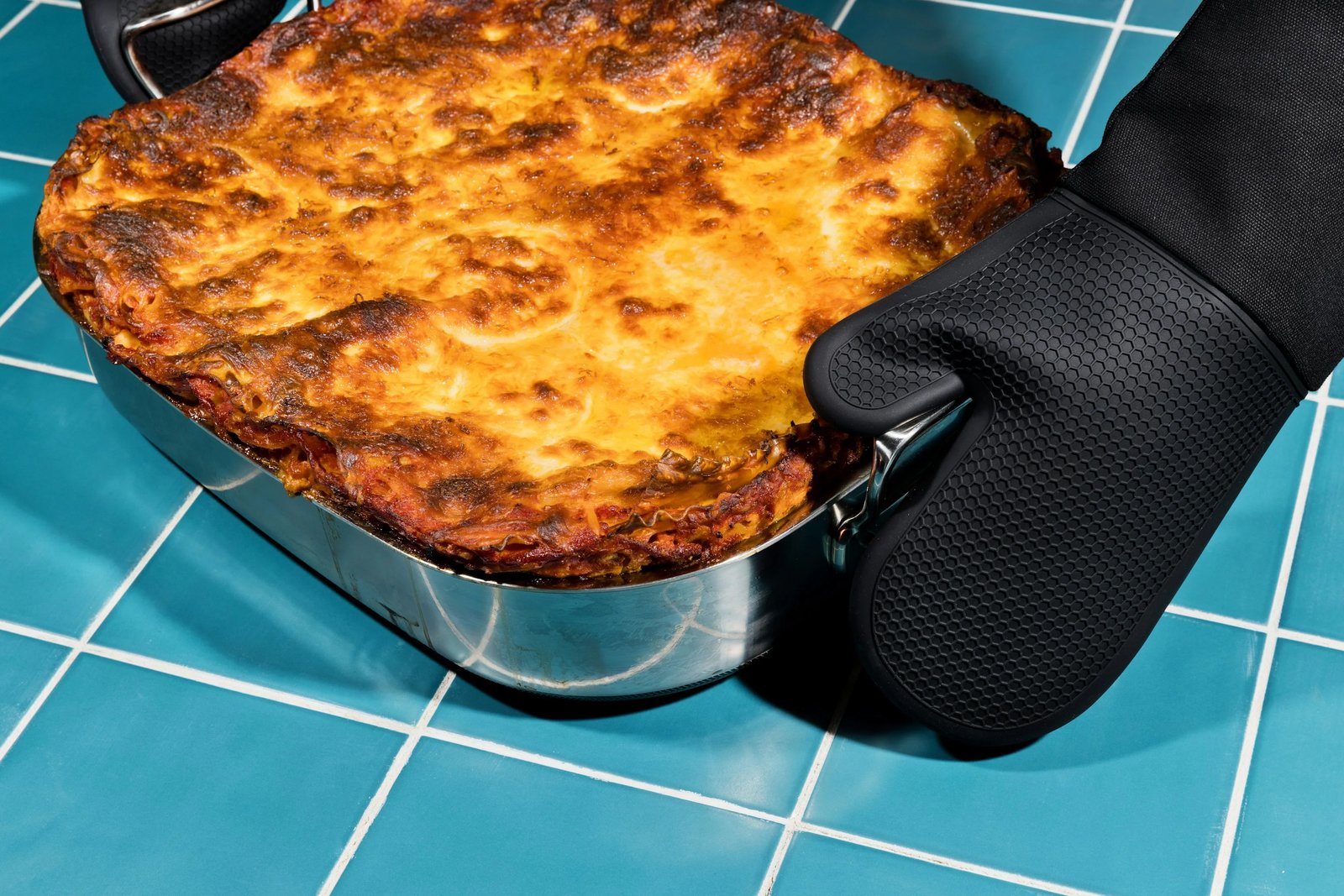 Moving a HexClad pan off the heat with an oven mitt
